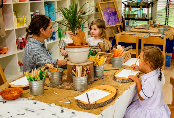 A group of children are sitting at a table in a classroom.
