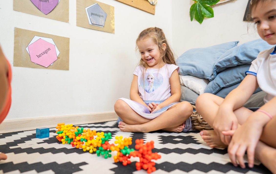 A group of children playing with blocks in a room.